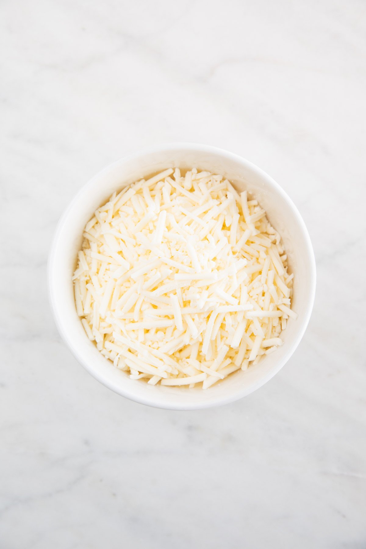 A bowl with shredded vegan mozzarella.