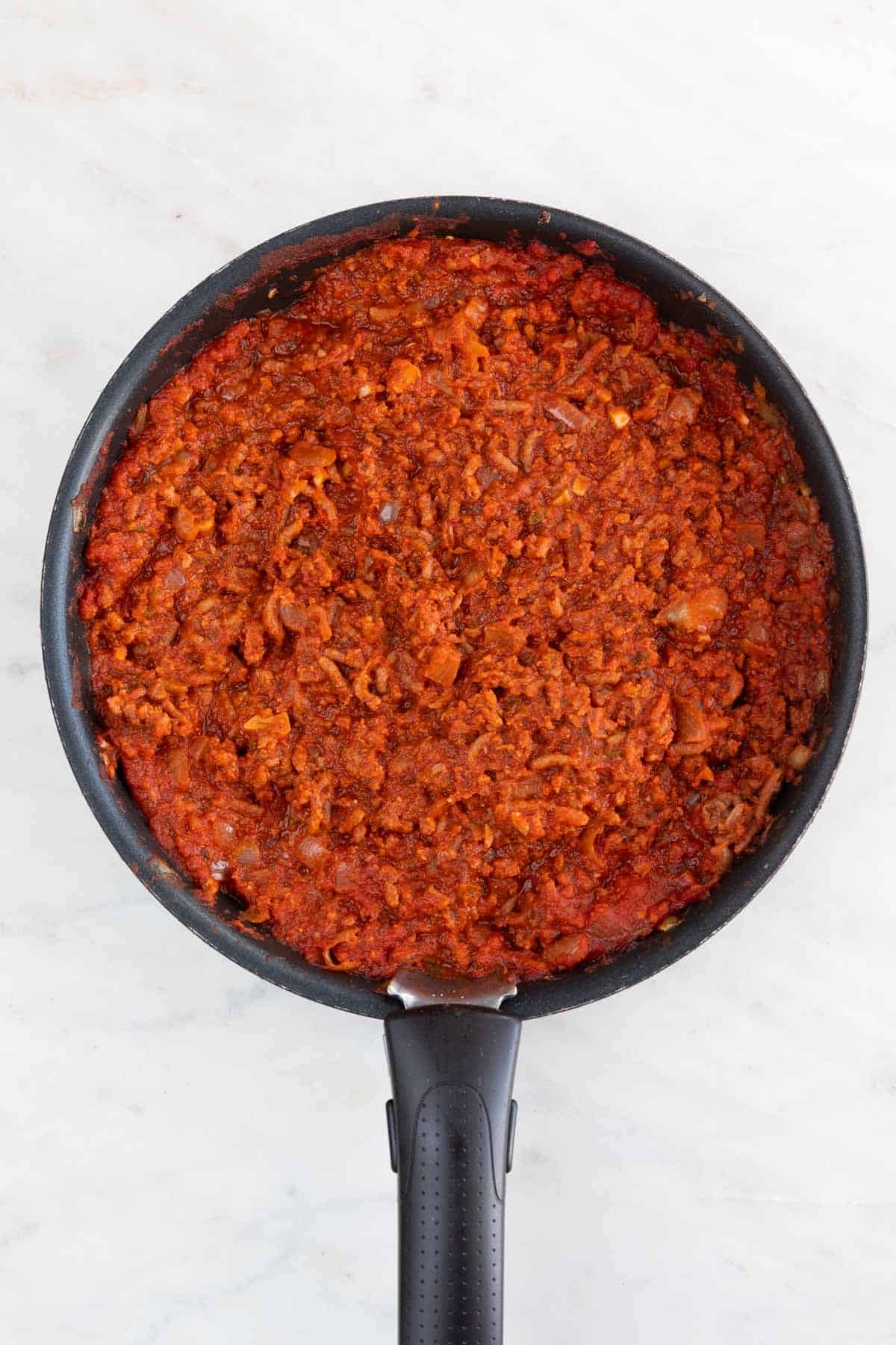 A skillet with the cooked vegan meat sauce.