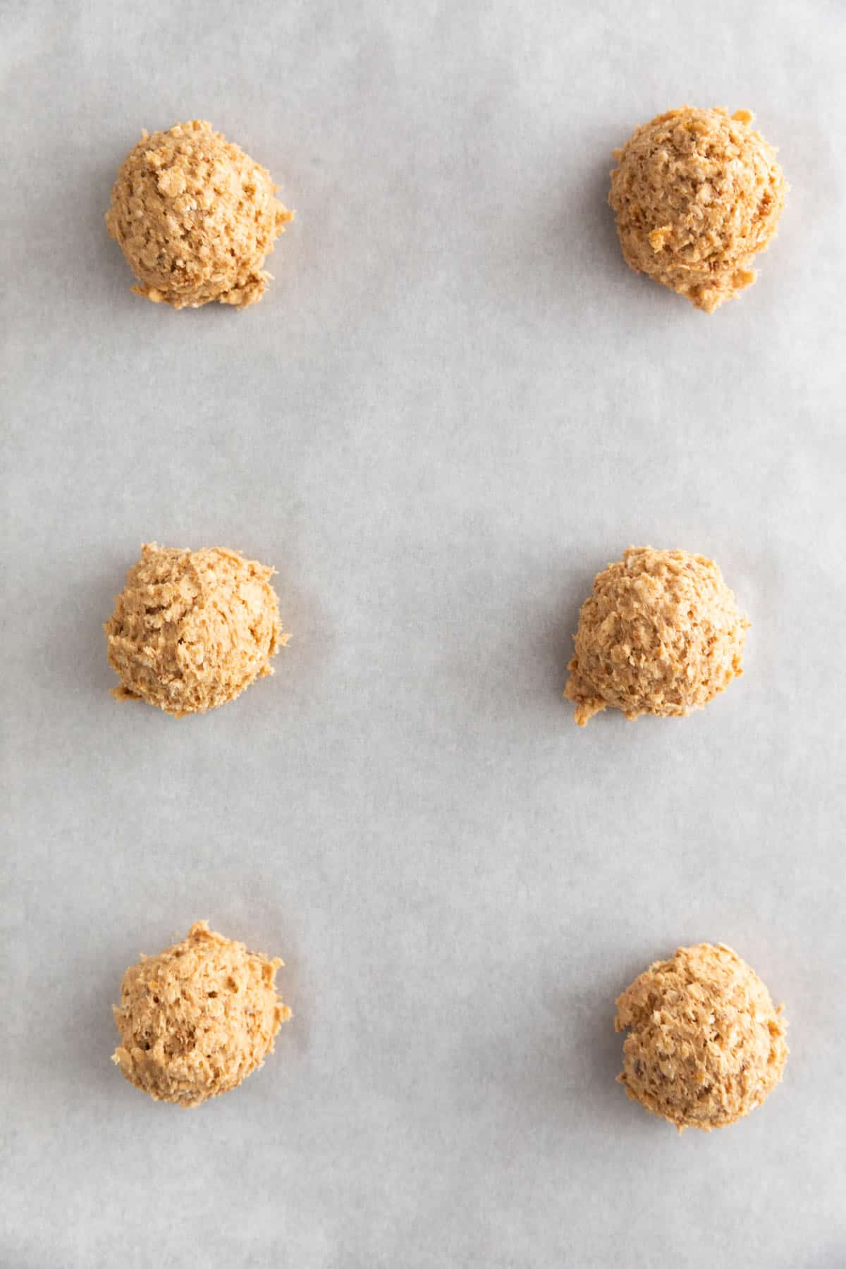 Cookie balls onto a lined baking sheet.