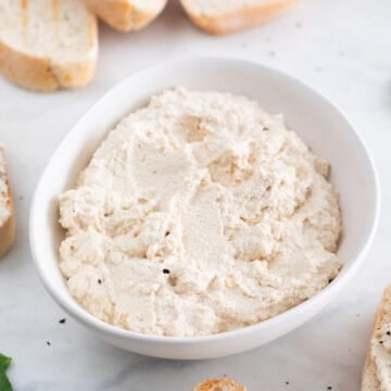 A bowl with vegan tofu ricotta cheese and some bread slices around.