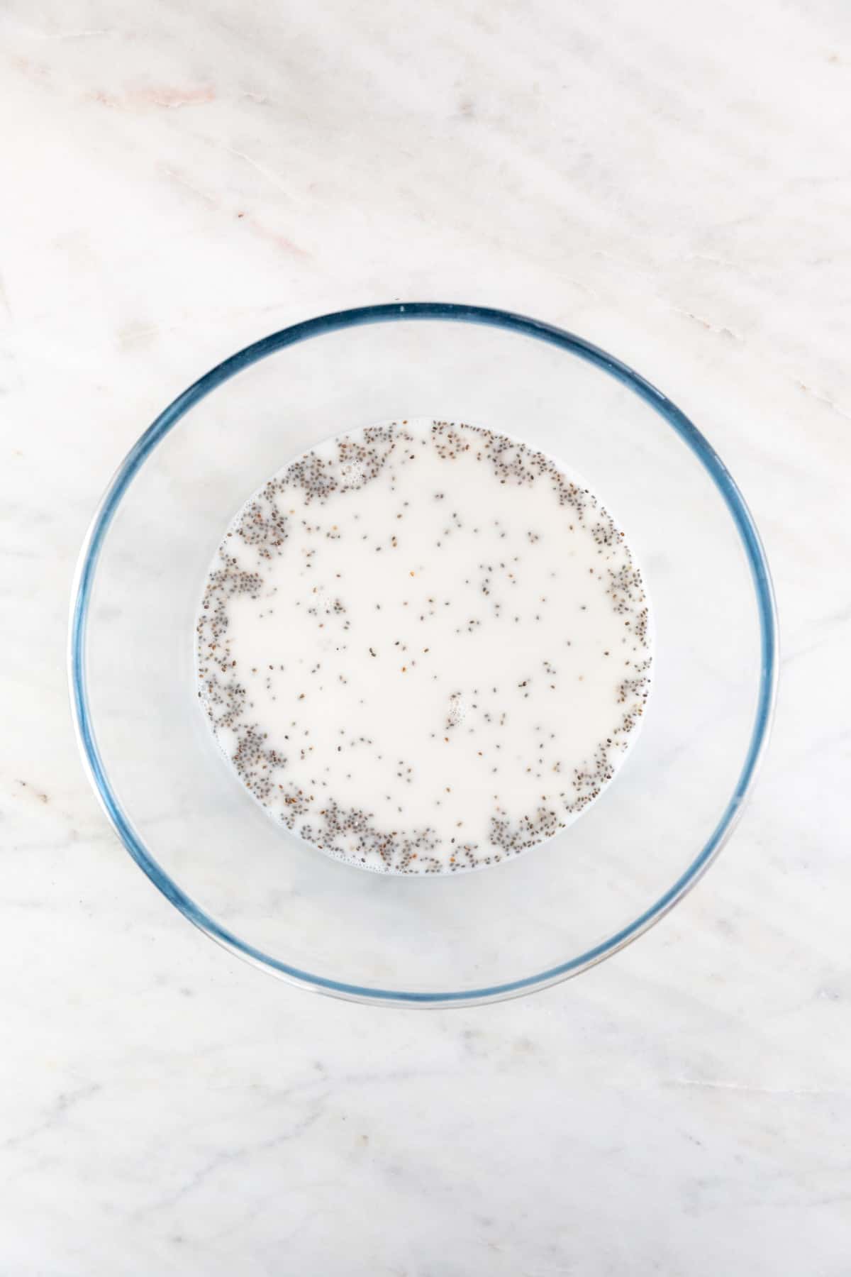 A large mixing bowl with the wet ingredients and the chia seeds mixed.