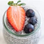 A jar of chia pudding with some berries on top.