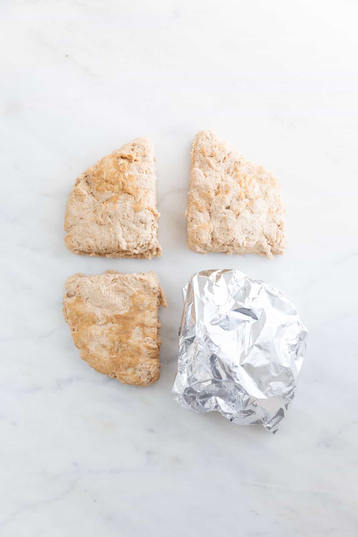 The dough flatten and cut into 4 pieces, one of them wrapped in aluminum foil.