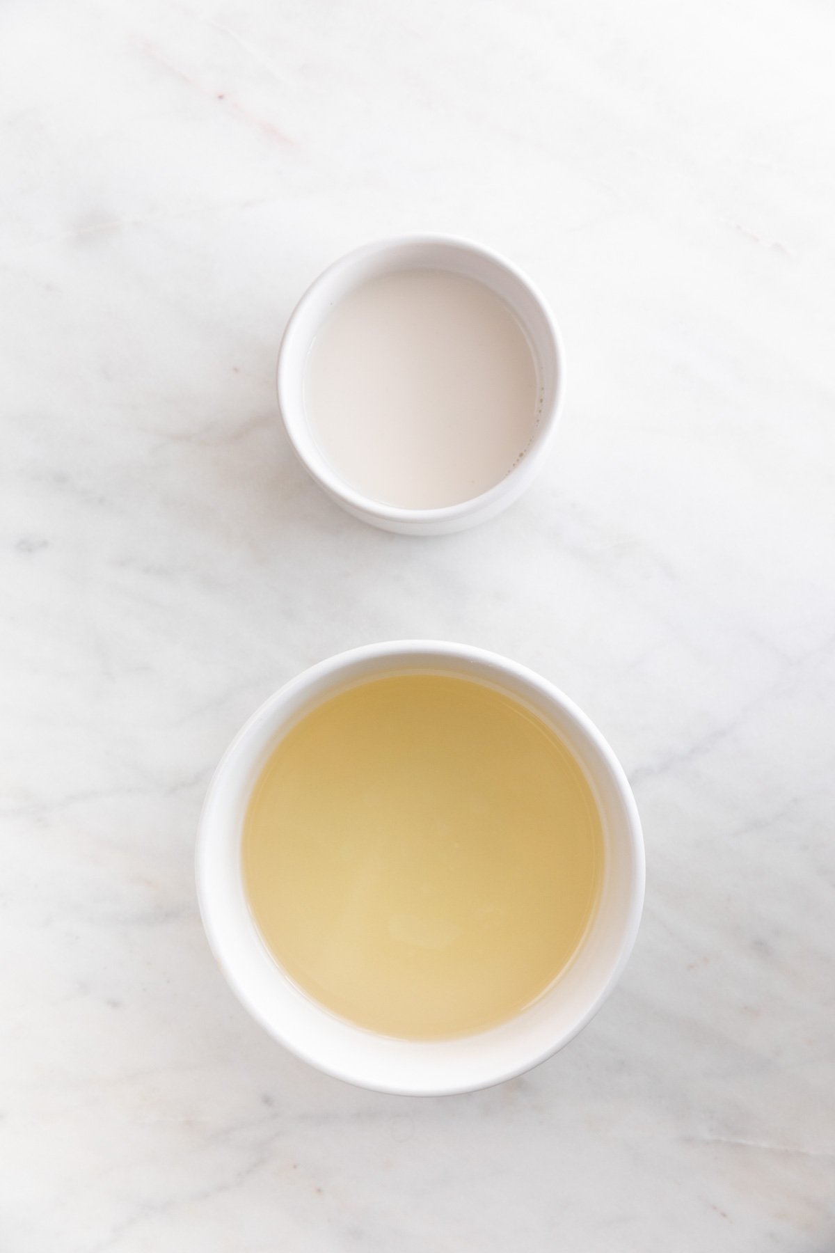 A bowl with soy milk and another bowl with oil.