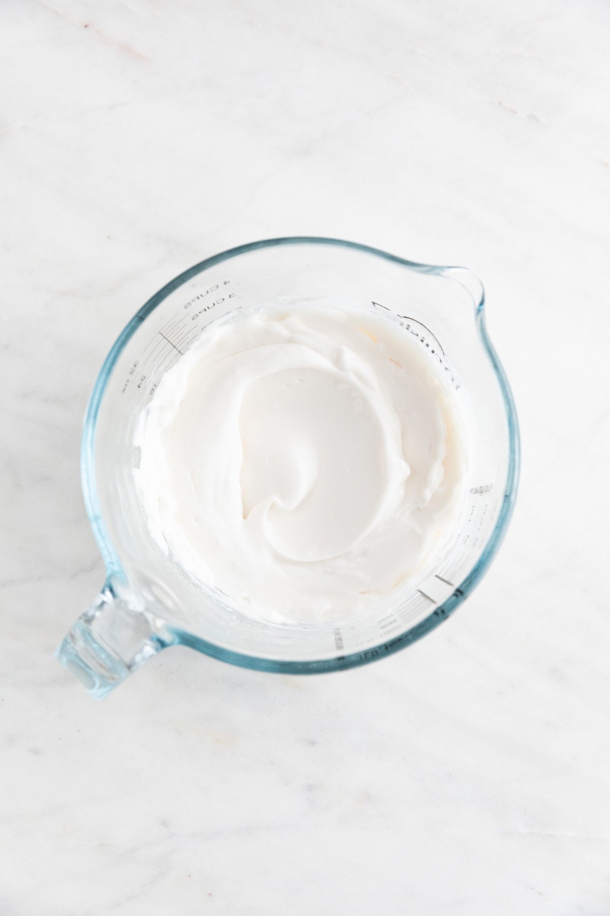 The vegan mayonnaise in a glass measuring cup.