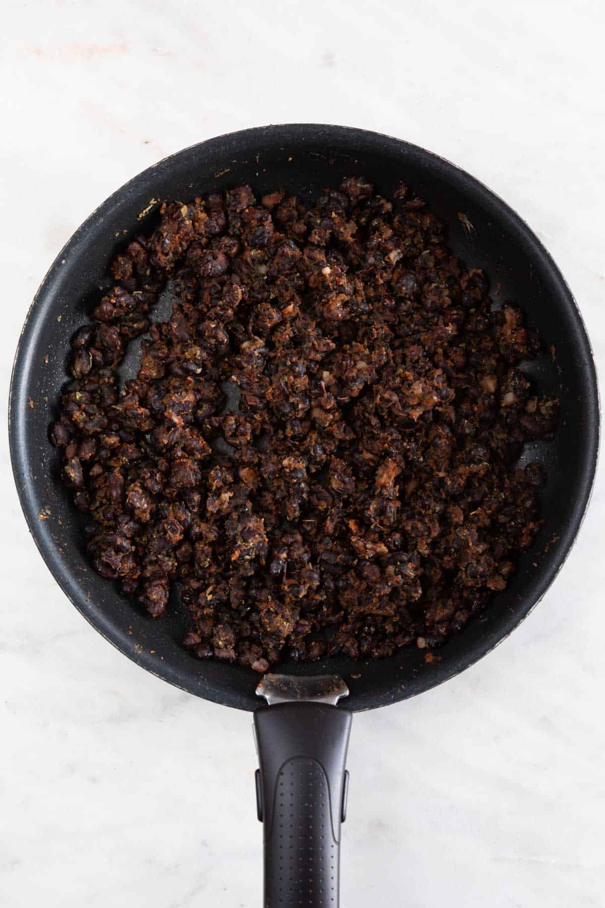 A skillet with the black bean filling fully cooked.