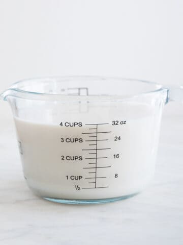 A glass measuring cup with milk.