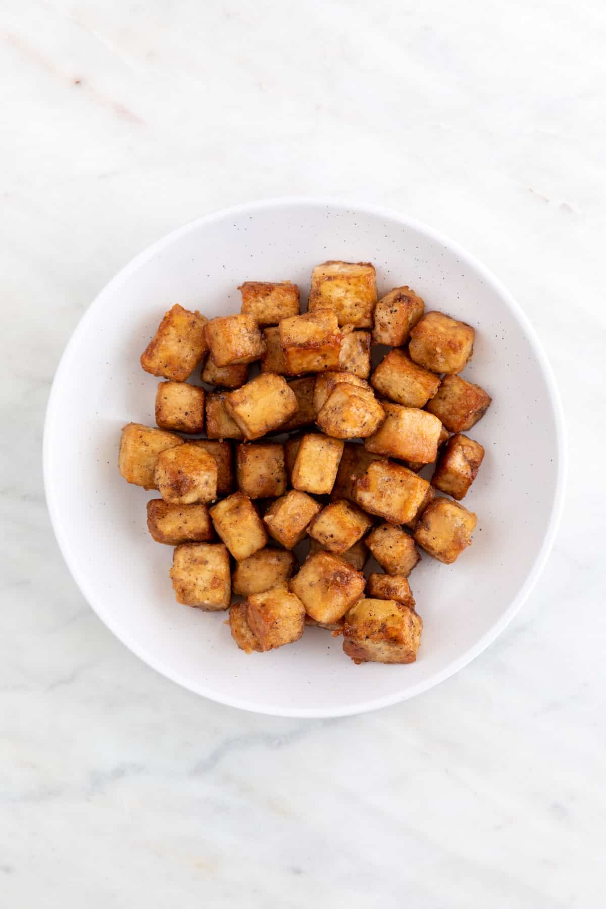 Fried tofu cubes on a plate.