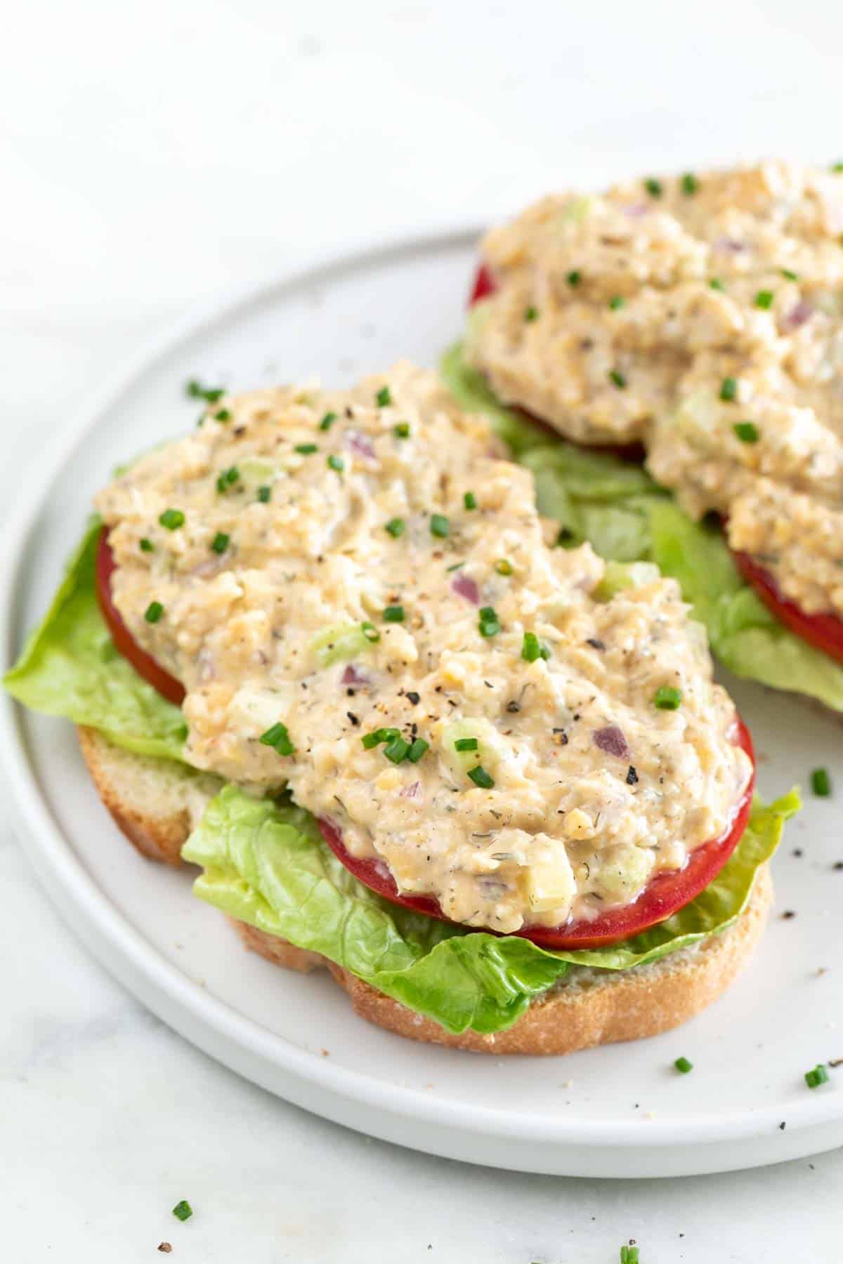 Open sandwich with lettuce, tomato slices and vegan chicken salad.