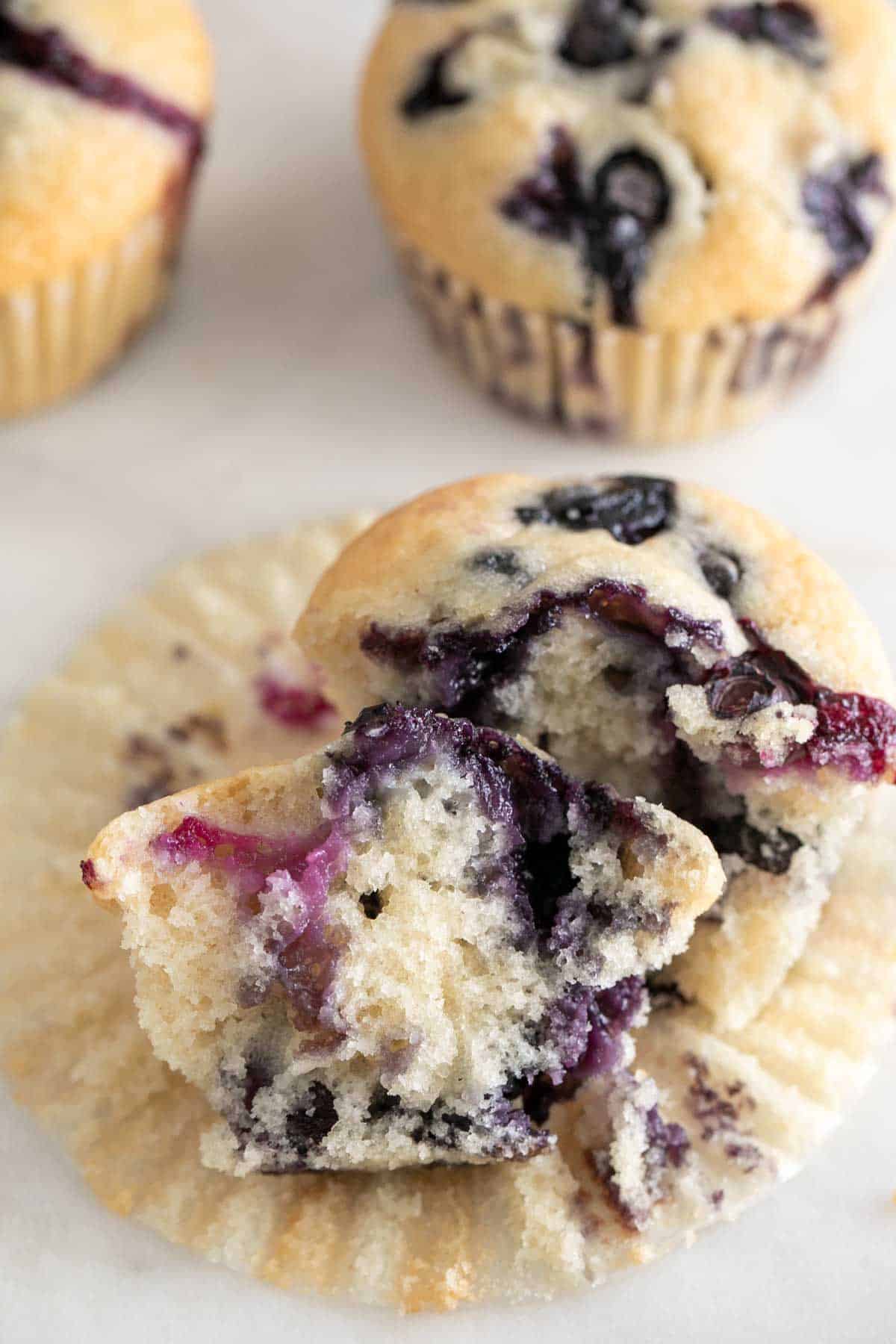 Vegan blueberry muffin, cut in half to reveal its moist and fruity interior.