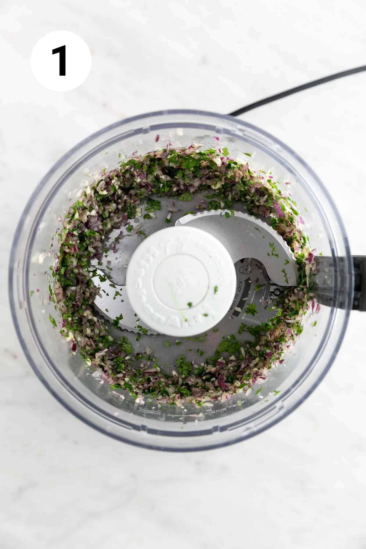 Garlic, red onion, and cilantro finely chopped in a food processor.