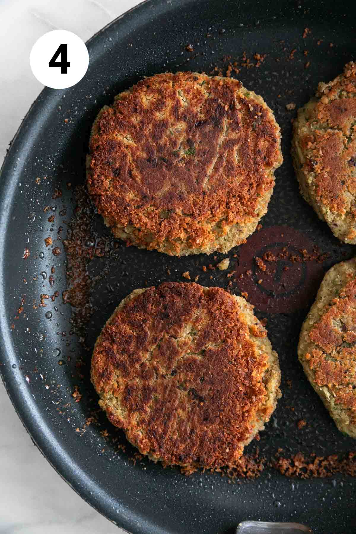 Cooked vegan chickpea burgers in a skillet.