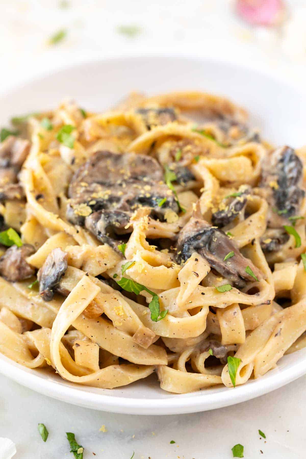 Garnished vegan mushroom pasta plate adorned with finely chopped cilantro.