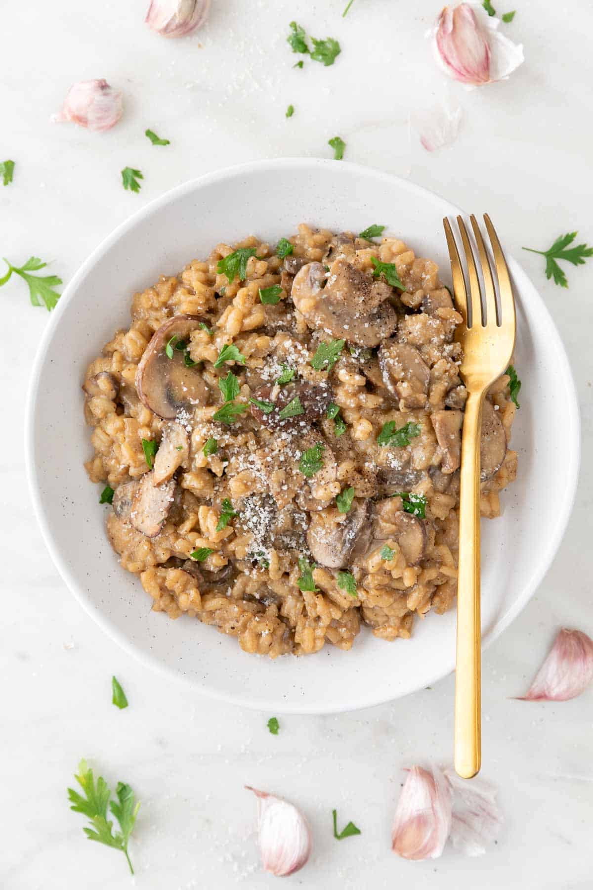 Vegan mushroom risotto on a plate with a fork.