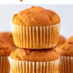 Stacked vegan pumpkin muffins with extras nearby.