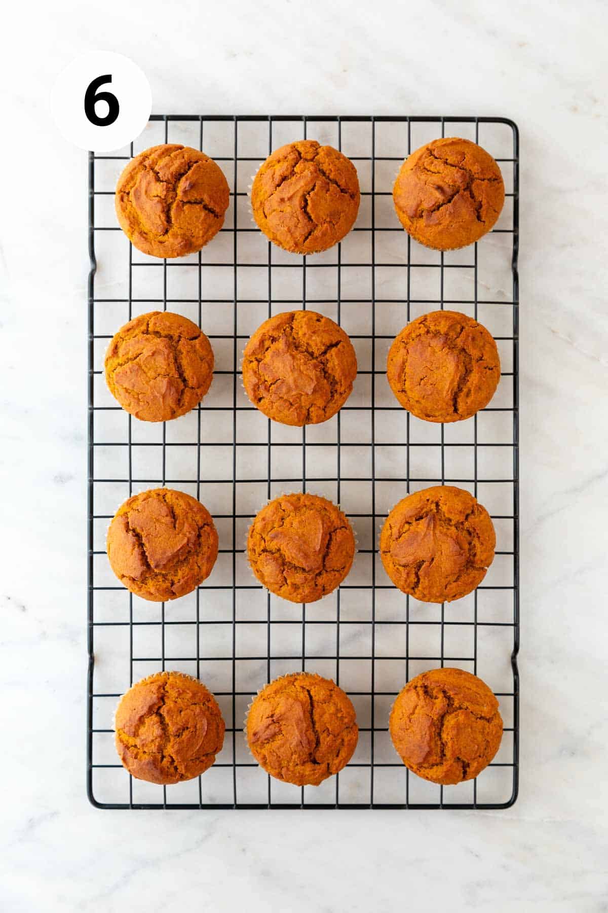 Baked vegan pumpkin muffins on a cooling rack.