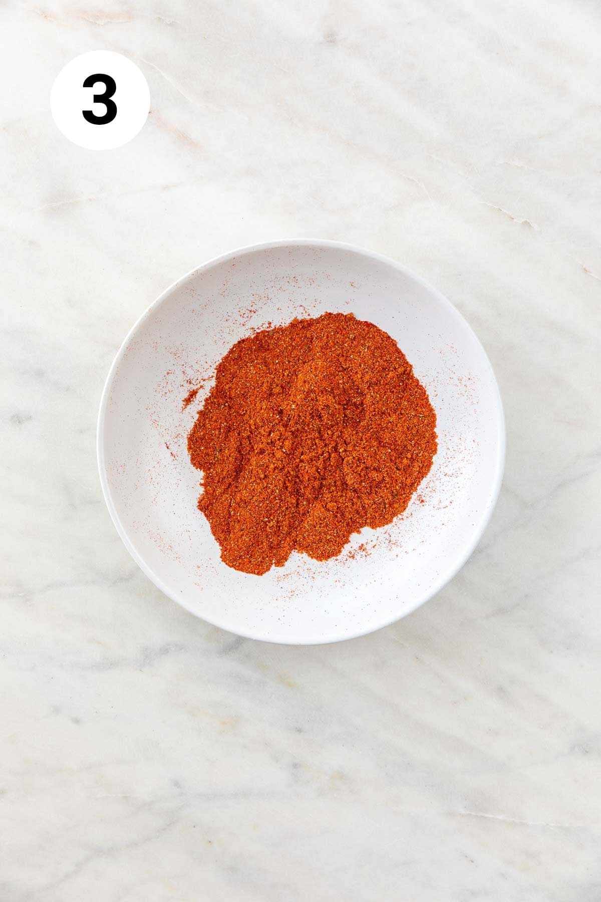 Homemade chili powder in a shallow dish after grinding in a spice grinder.