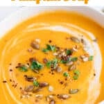 Pumpkin soup bowl with coconut milk, parsley, and black pepper garnish.