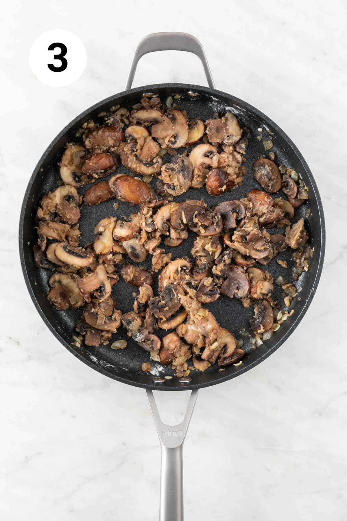 Onion, garlic, and mushrooms sautéed in a skillet with flour.