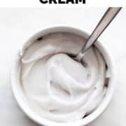 Bowl of vegan whipped cream with a spoon inside.
