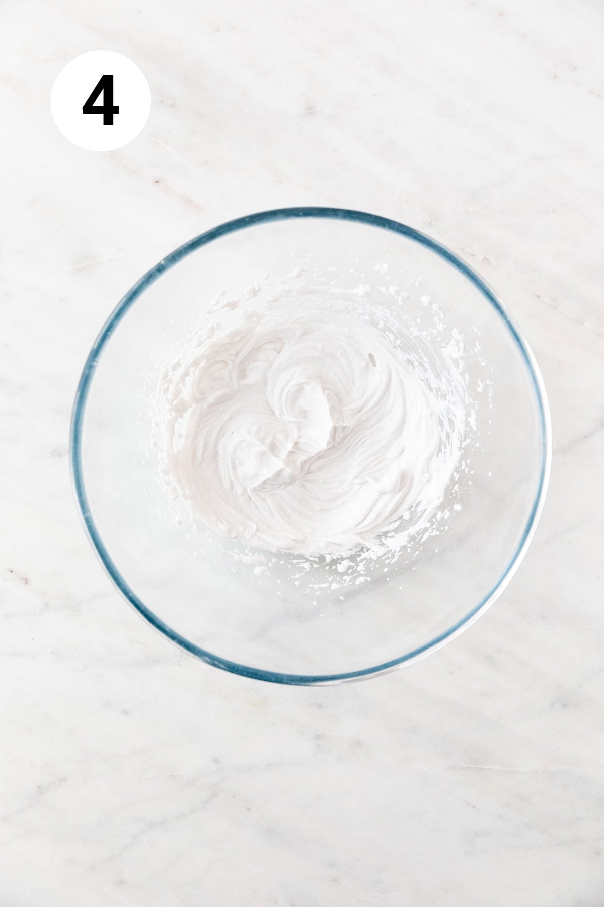Whipped coconut cream in a large mixing bowl.