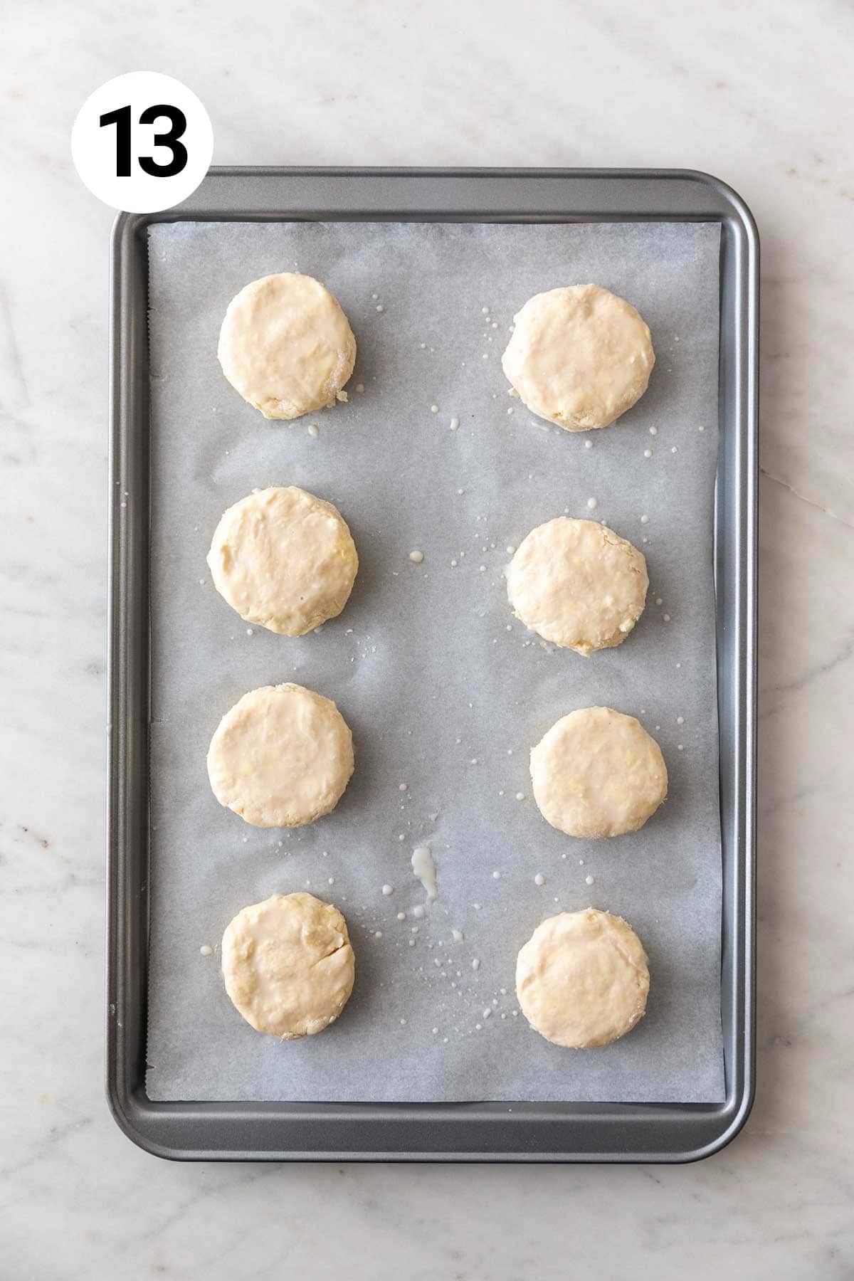 Vegan biscuits on a lined baking sheet before baking.