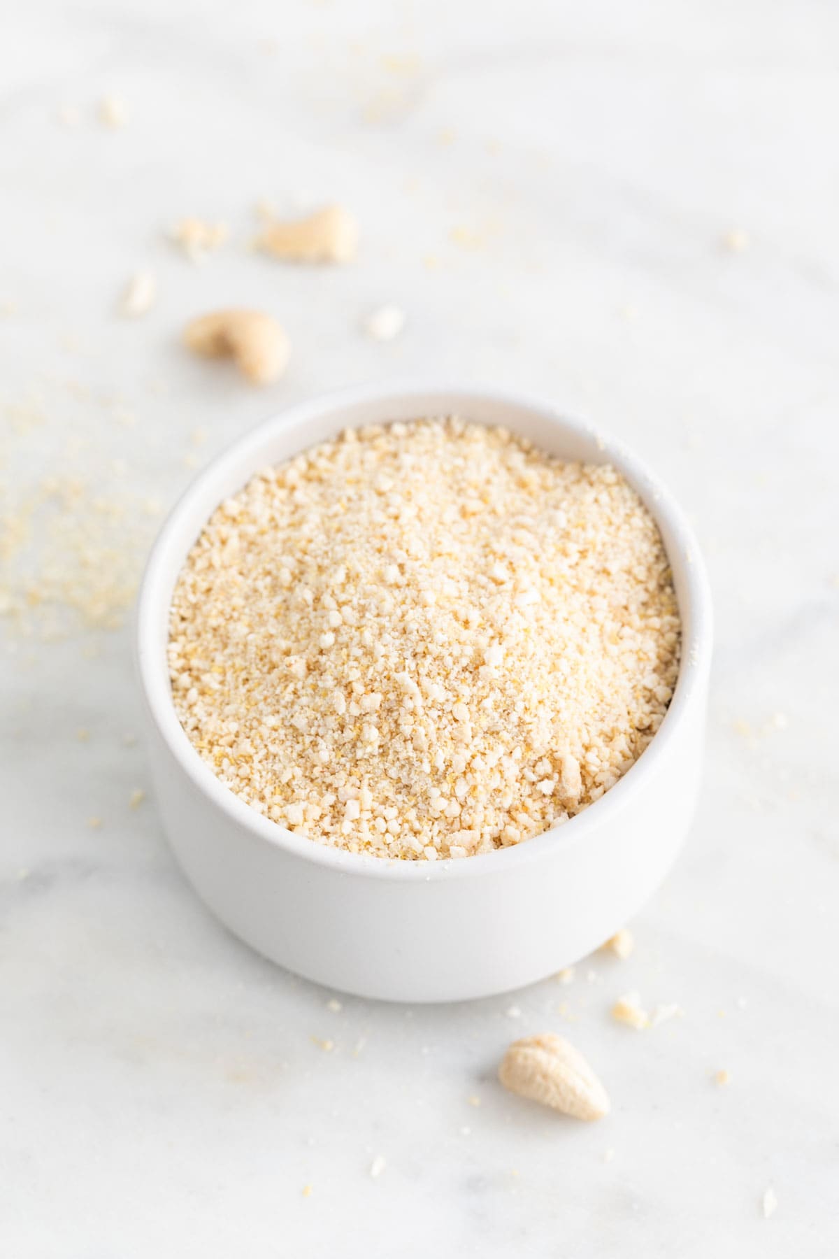 Small white bowl with vegan Parmesan cheese.