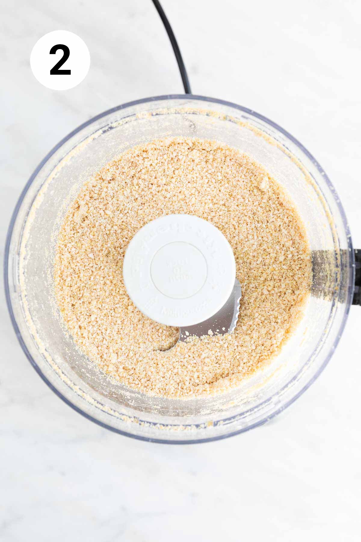 Food processor with finished vegan Parmesan cheese.