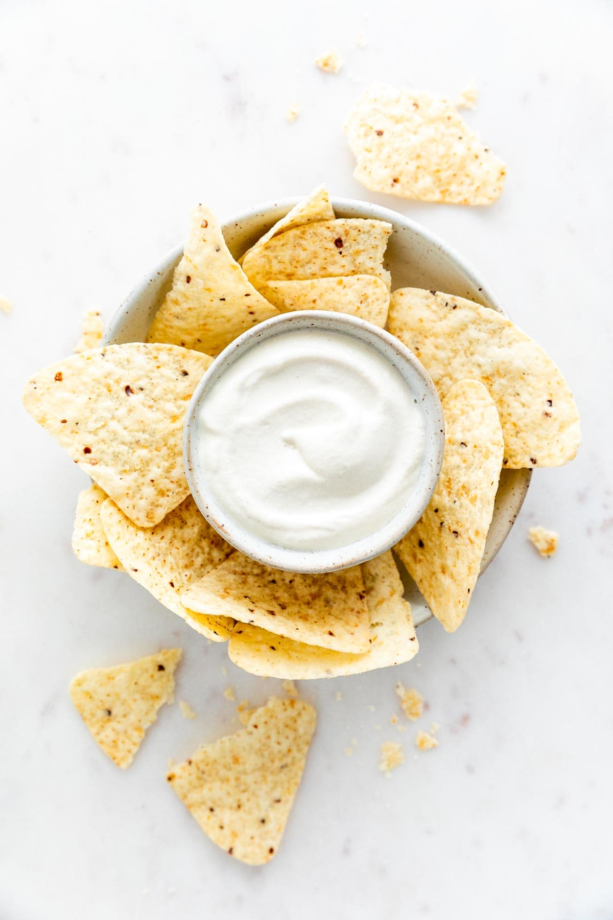 Bowl of vegan sour cream with tortilla chips.