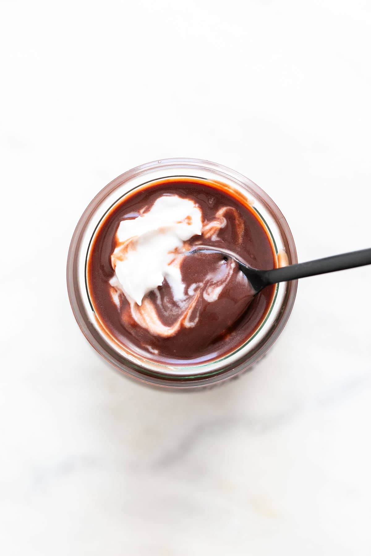 Vegan chocolate pudding in a glass with a spoon.