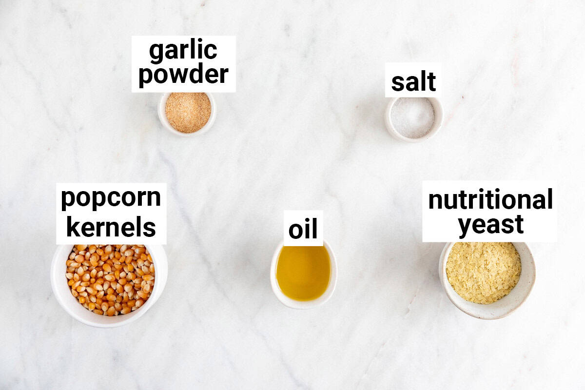 Ingredients needed to make cheesy vegan popcorn.
