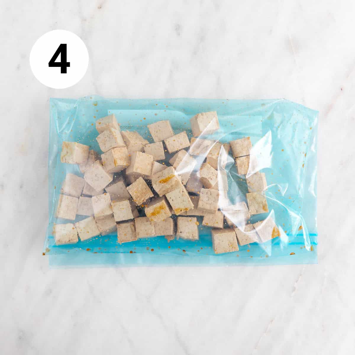 Tofu cubes with soy sauce in a large ziplock bag.