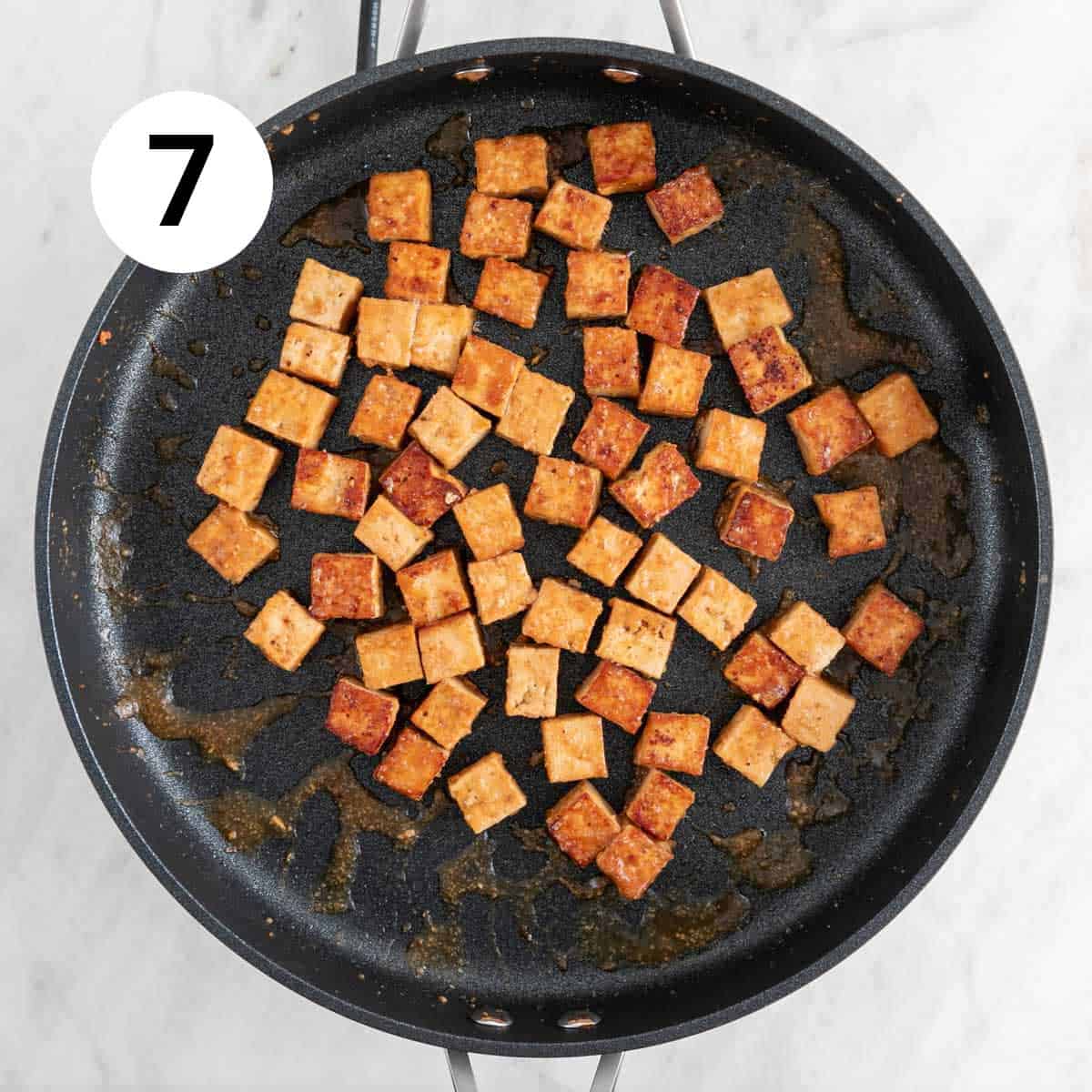 Marinated tofu cooked in a skillet.