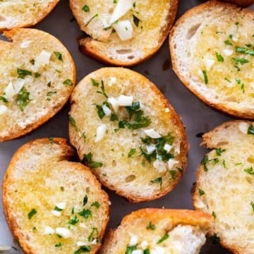 Vegan garlic bread arranged on a white platter.
