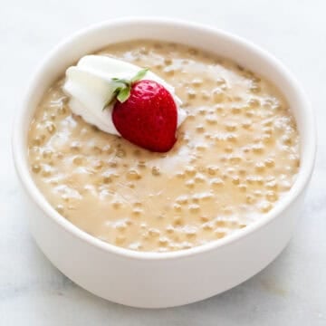 Vegan tapioca pudding with dairy-free whipped cream and fresh strawberry.