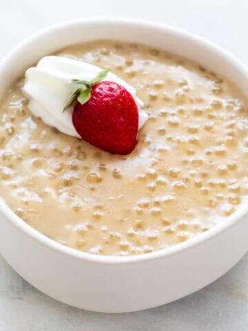 Vegan tapioca pudding with dairy-free whipped cream and fresh strawberry.