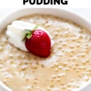 Vegan tapioca pudding in bowl garnished with vegan whipped cream and a strawberry.