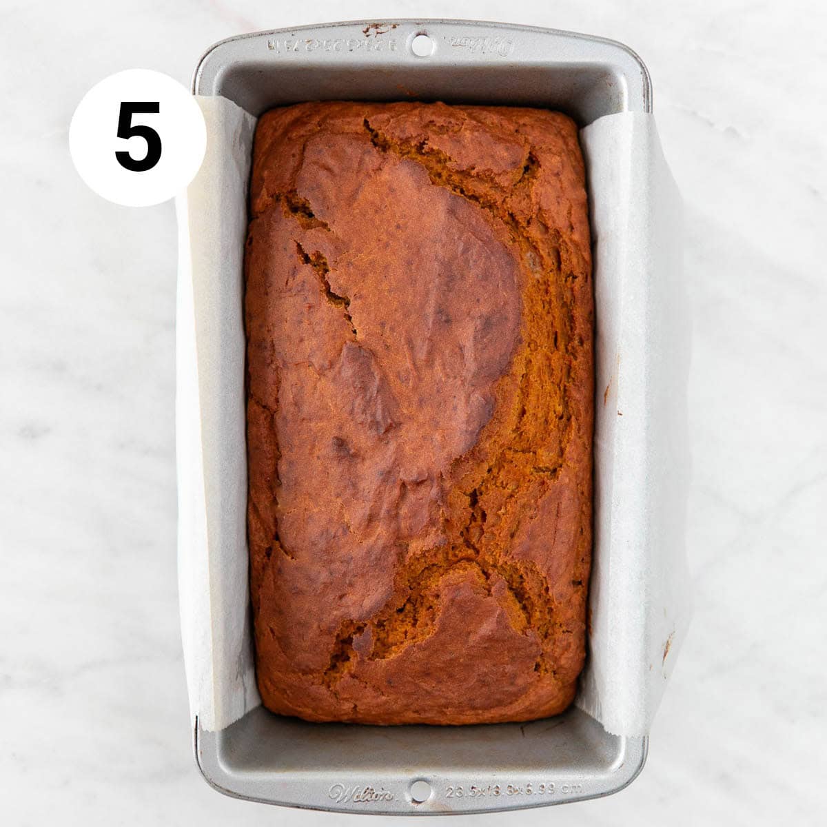 Baked vegan pumpkin bread in the lined loaf pan.