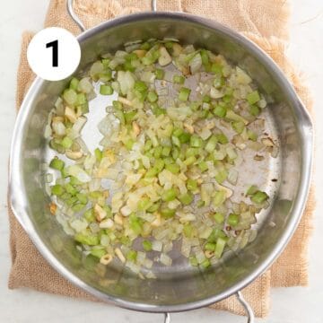 Large pot with sautéed garlic, onion, and celery.