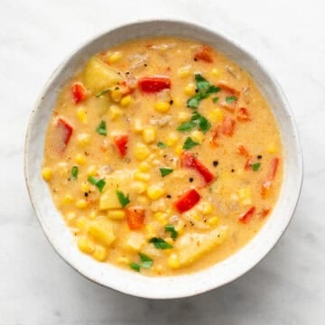 Vegan potato and corn chowder served in a bowl with parsley on top.