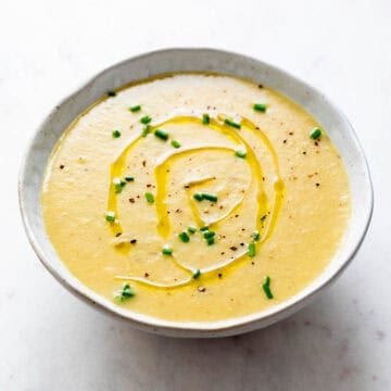 Vegan potato leek soup served in a bowl with toppings.