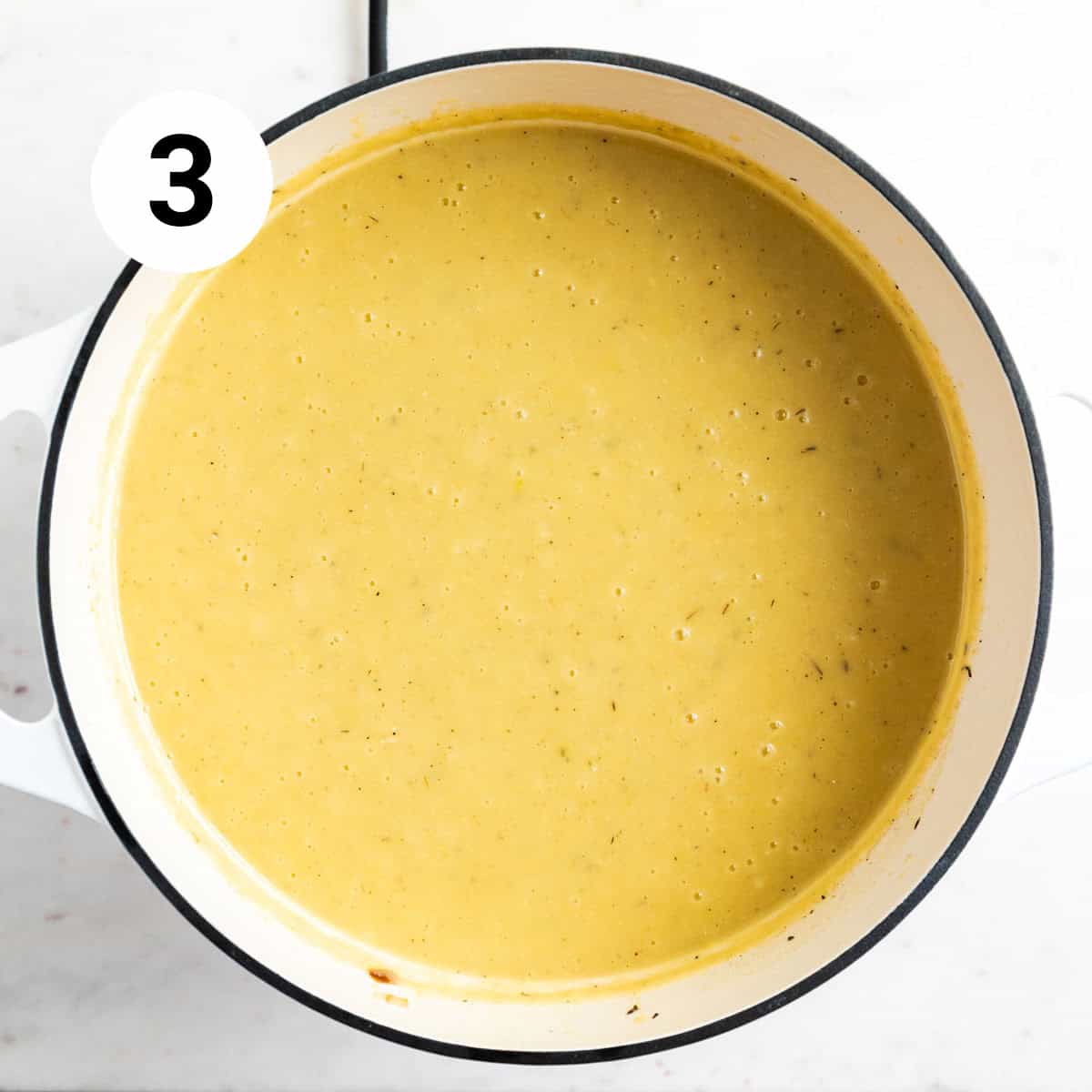 Blended vegan potato leek soup in a large pot.