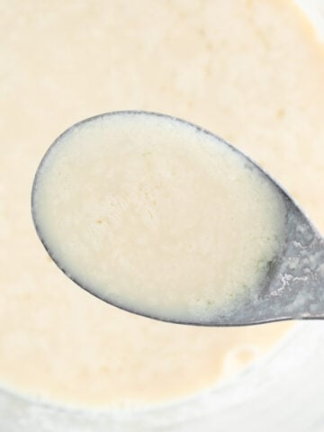 Measuring cup and spoon with vegan buttermilk.