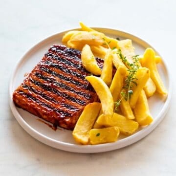 Toku steak, fries, and thyme on a plate.