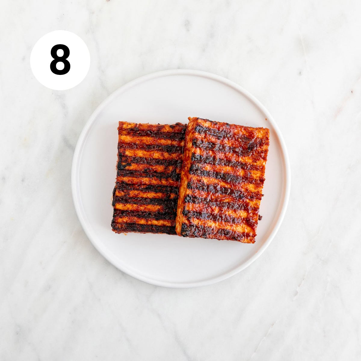 Two tofu steaks on a plate.