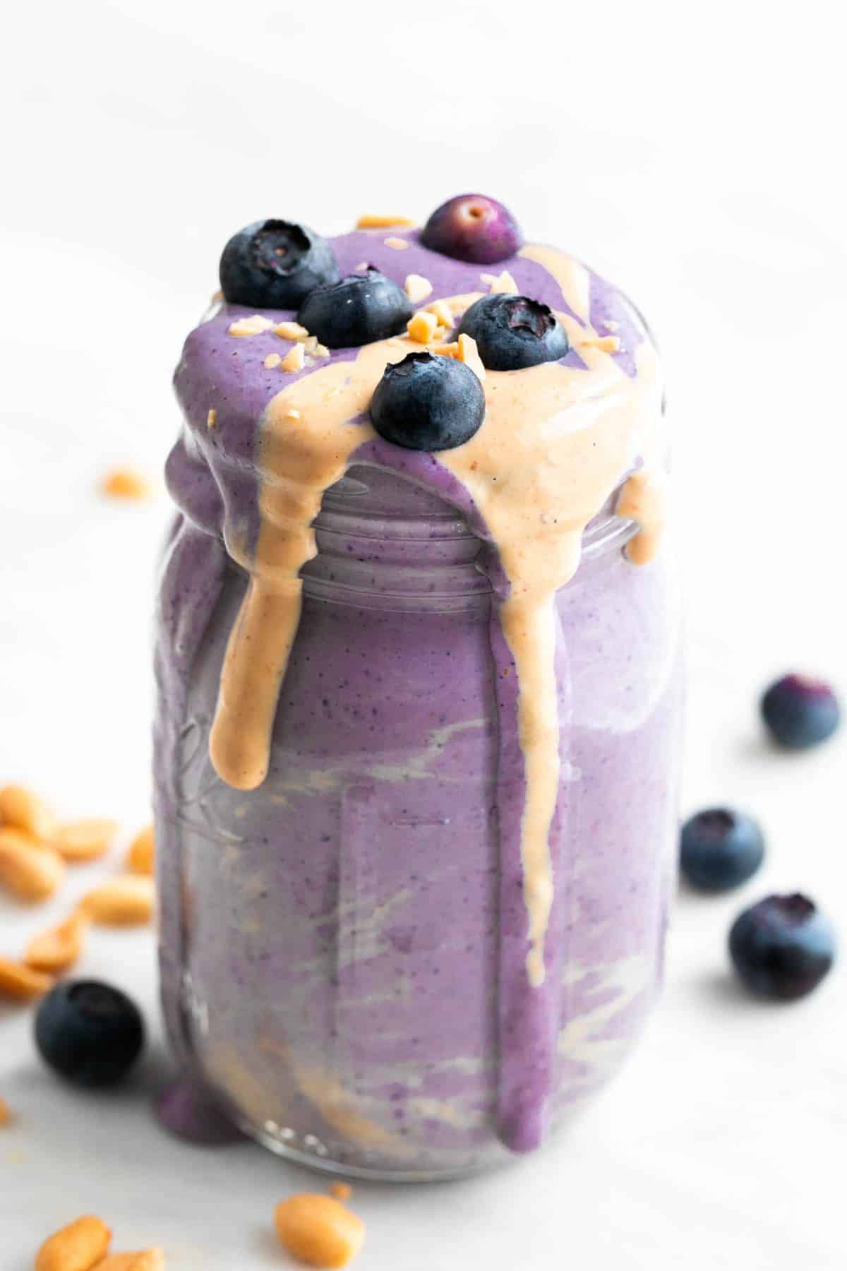 Silken tofu smoothie in a jar with toppings and ingredients arranged around it.