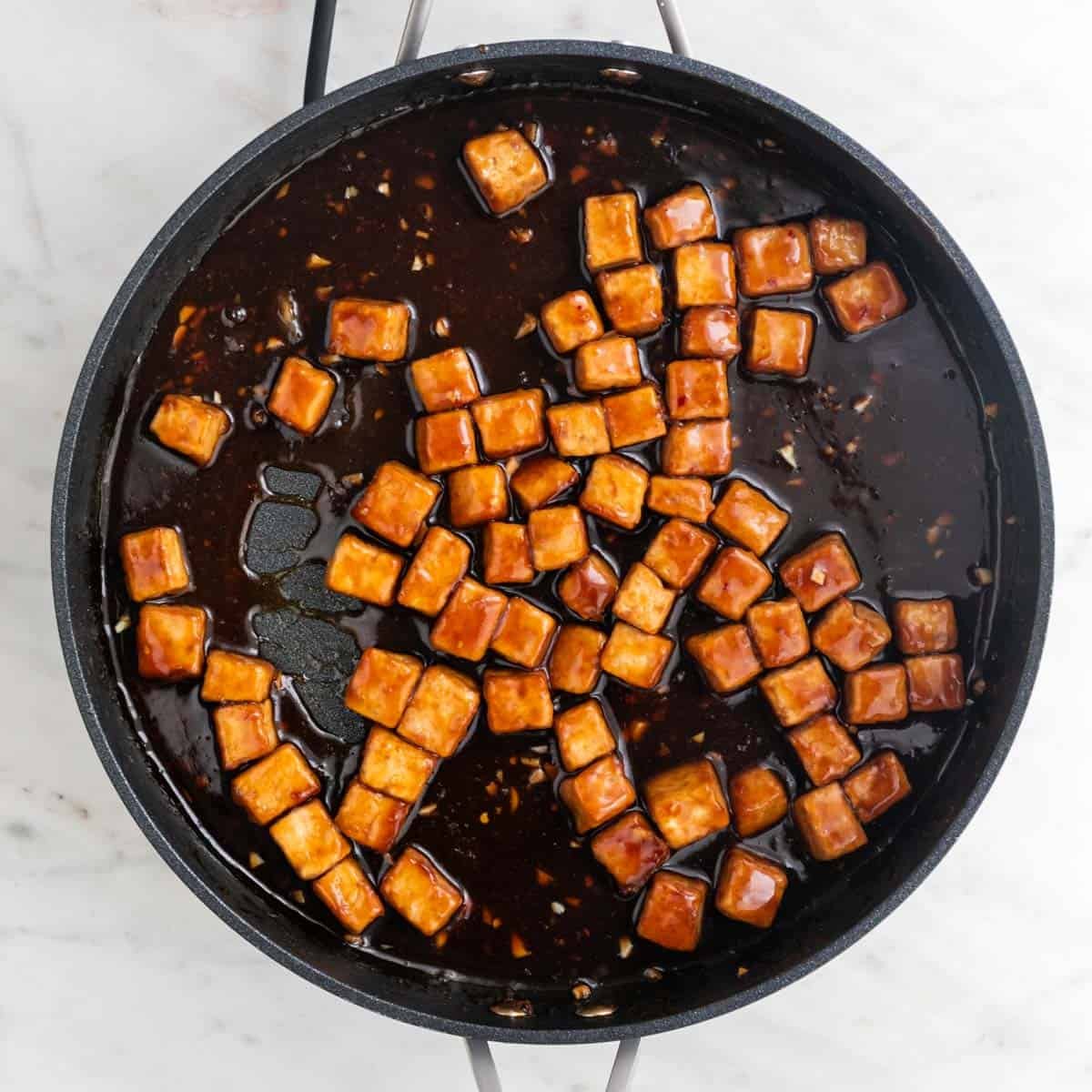 Orange tofu in a pan.