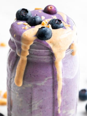 Silken tofu smoothie in a jar with toppings and ingredients arranged around it.