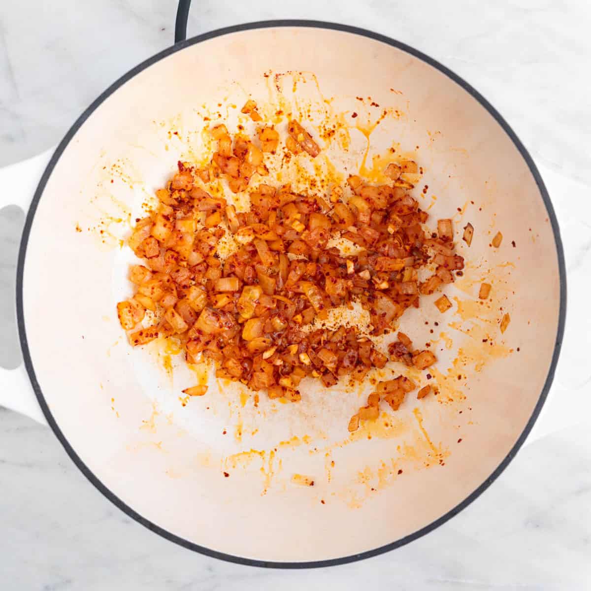 Sautéed onion, garlic, and gochugaru in a large pot.