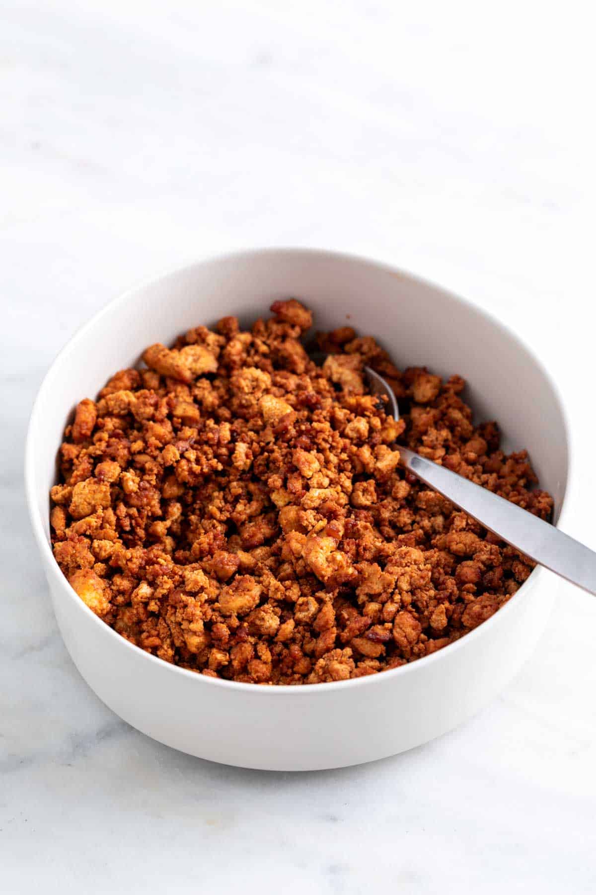 Tofu ground beef in a bowl with a spoon.